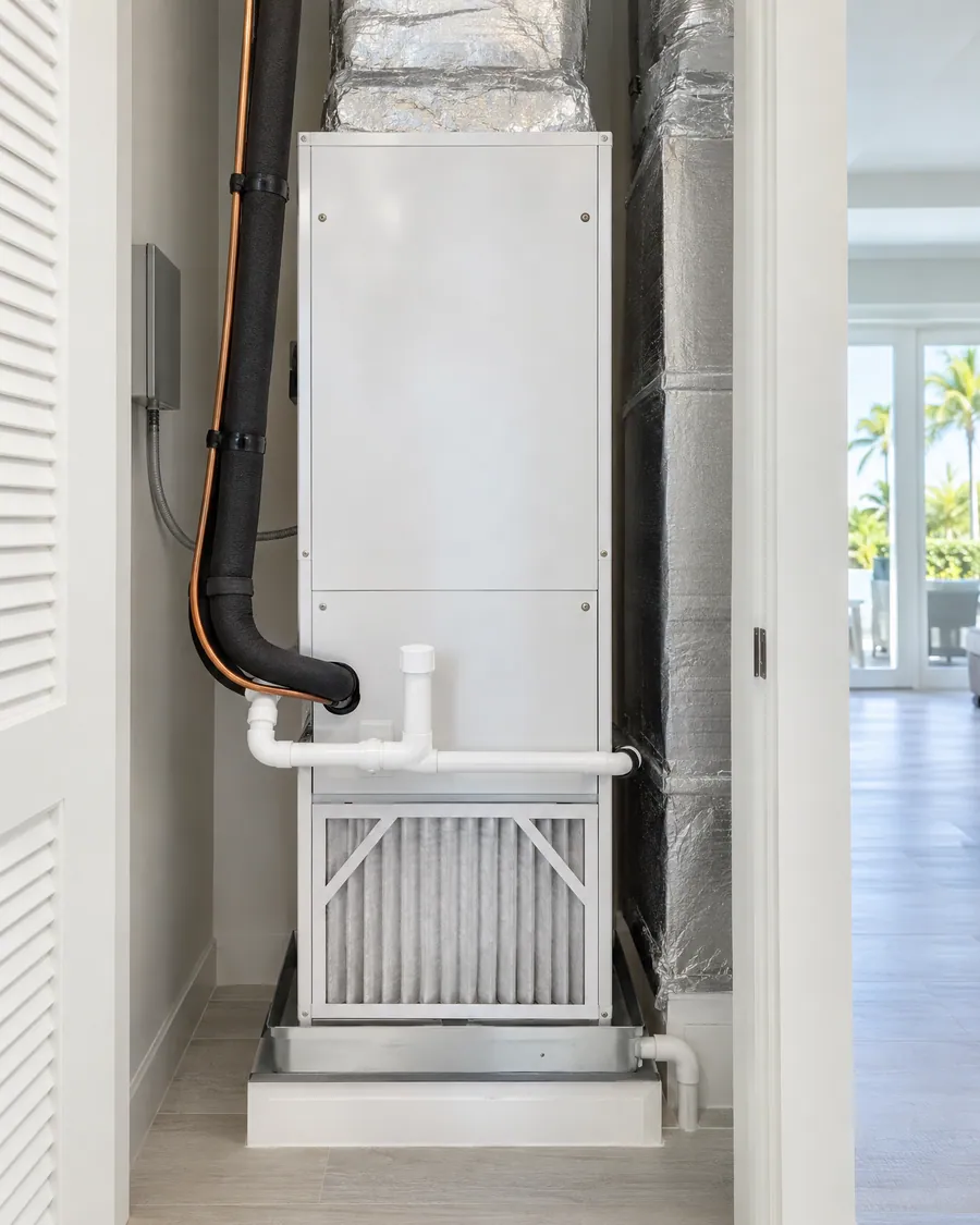 Indoor air handler in a utility closet with insulated copper lines, condensate drain and filter